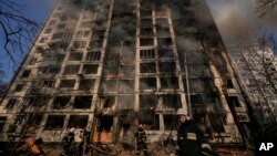 Firefighters work outside a destroyed apartment building after a bombing in a residential area in Kyiv, Ukraine, March 15, 2022.