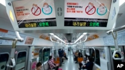 Digital screens showing safety precautions against the coronavirus are seen in a subway train in in Seoul, South Korea, March 22, 2022. 