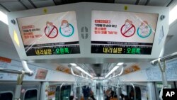 Digital screens showing safety precautions against the coronavirus are seen in a subway train in in Seoul, South Korea, March 22, 2022. 