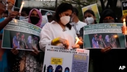 In this file photo, people hold placards and candles in Bengaluru, India, during a protest against banning Muslim girls from wearing the hijab in educational institutions in southern Karnataka state, Feb. 19, 2022. (AP Photo/Aijaz Rahi, File)