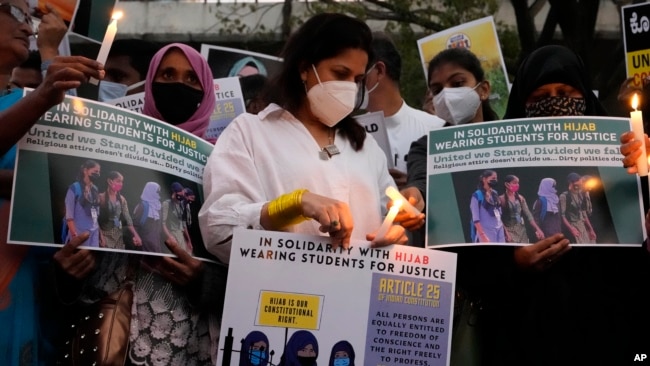 In this file photo, people hold placards and candles in Bengaluru, India, during a protest against banning Muslim girls from wearing the hijab in educational institutions in southern Karnataka state, Feb. 19, 2022. (AP Photo/Aijaz Rahi, File)