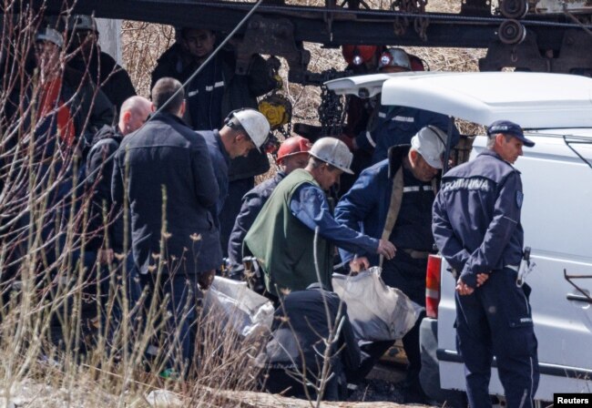 Para penambang mengangkat jenazah korban kecelakaan tambang batu bara di Sokobanja, Serbia selatan, ke kendaraan, 1 April 2022. (REUTERS/Antonio Bronic)