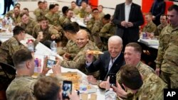 拜登总统与驻波兰的美国军人一道吃披萨饼。(2022年3月25日)