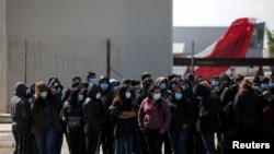 Deportados guatemaltecos se reúnen frente a un centro de migración del gobierno después de llegar en un vuelo de deportación desde los EE. UU., en la sede de la Fuerza Aérea de Guatemala (FAG) en el aeropuerto internacional La Aurora, Guatemala, el 28 de diciembre de 2021.