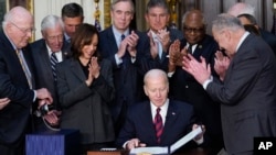 조 바이든(가운데) 미국 대통령이 15일 백악관에서 정부지출법안에 서명한 직후 카멀라 해리스(앞줄 왼쪽 세번째) 부통령과 척 슈머(오른쪽) 상원 민주당 대표 등 정계 주요 인사들이 박수하고 있다.