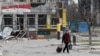 A man walks near a building damaged in the course of the Ukraine-Russia conflict in the southern port city of Mariupol, Ukraine, April 1, 2022.