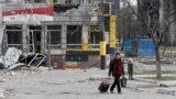 A man walks near a building damaged in the course of the Ukraine-Russia conflict in the southern port city of Mariupol, Ukraine, April 1, 2022.