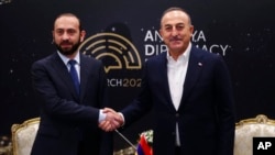 In this photo provided by Turkish Foreign Ministry, Armenia's Foreign Minister Ararat Mirzoyan, left, shakes hands with his Turkish counterpart Mevlut Cavusoglu during a meeting in Antalya, Turkey, March 12, 2022.