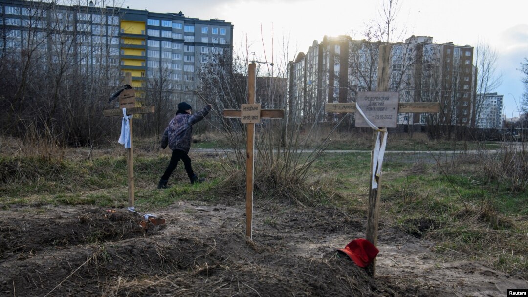 Dječak porolazi pord grobova sa tijelima civila koje su, prema navodima stanovnika, ubile ruske snage u Buči. (Foto: REUTERS/Vladyslav Musiienko)