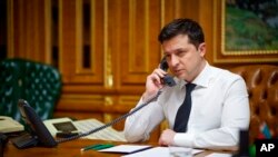 FILE - Ukrainian President Volodymyr Zelenskyy speaks with U.S. President Joe Biden by phone in his office in Kyiv, Ukraine, Dec. 9, 2021. The two spoke again on March 11, 2022, with Biden providing an update on efforts to raise the cost of war for Russian President Vladimir Putin. (Ukrainian Presidential Press Office)