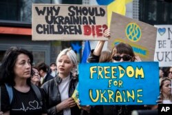 Demonstrators hold posters outside the EU summit in Brussels, Belgium, March 24, 2022.