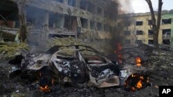 গোলাগুলিতে বিদ্ধস্থ ইউক্রেনের একটি প্রসূতি হাসপাতালের সামনে পুড়ে যাওয়া গাড়ি। (ছবি- রয়টার্স) 