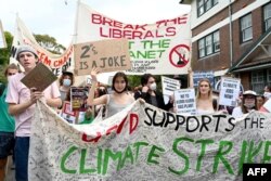 Anak-anak sekolah meneriakkan slogan-slogan sambil berbaris menuju rumah PM Australia Scott Morisson di Sydney, 25 Maret 2022, dalam aksi mogok dan protes menyoroti kemajuan yang tidak memadai untuk mengatasi perubahan iklim. (Muhammad FAROOQ/AFP)