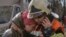 Un bombero consuela a una mujer frente a un edificio de apartamentos destruido después de un atentado con bomba en una zona residencial de Kiev, Ucrania.