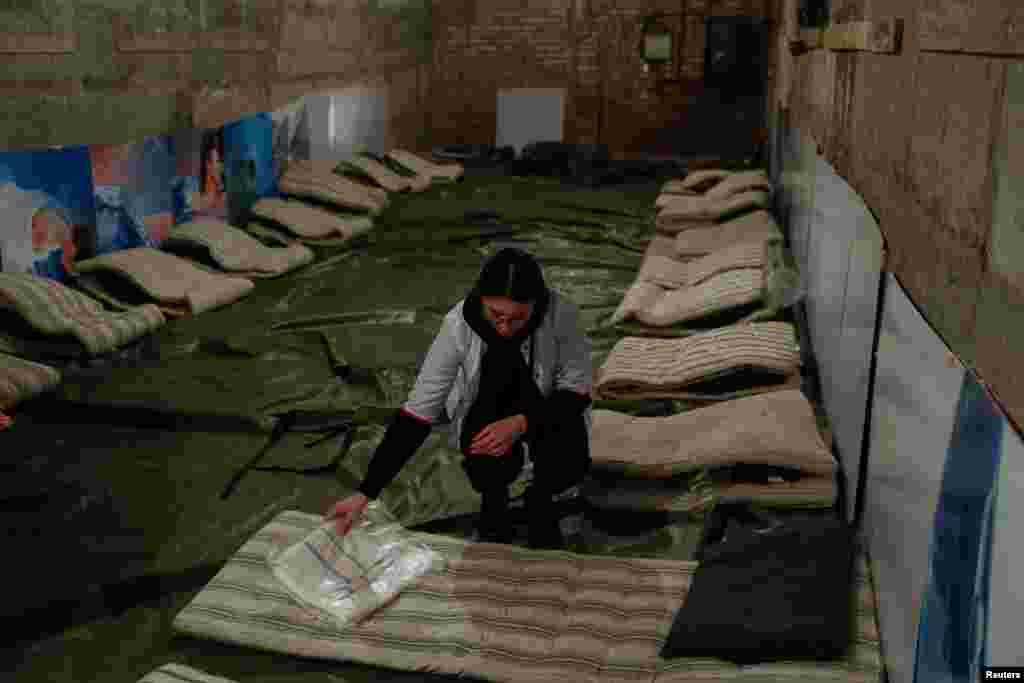 Kateryna Safronova, a medical student, prepares beds in a makeshift hospital inside a bomb shelter in Kyiv Region, March 14, 2022.