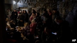 People gather in a basement, used as a bomb shelter, during an air raid in Lviv, western Ukraine, March 19, 2022.