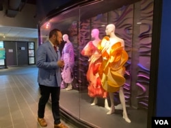 Kepala desain fesyen FIDM Nick Verreos melihat-lihat rancangan Illene Martoseno yang sedang dipajang di kampus FIDM (VOA Maret 2022)
