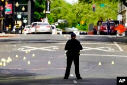 A Sacramento City Police Officer stands near a field of evidence markers after a mass shooting In Sacramento, Calif., April 3, 2022.