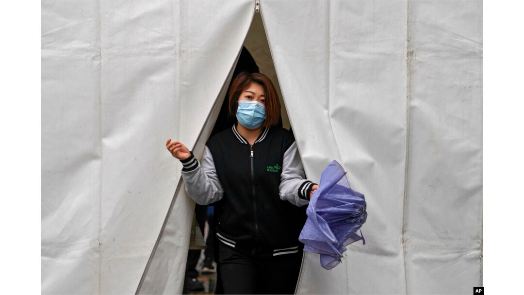 A woman walks out from a tent after getting a COVID-19 test, in Beijing, March 29, 2022.