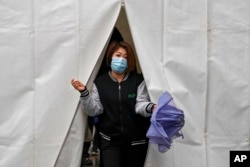 A woman walks out from a tent after getting a COVID-19 test, in Beijing, March 29, 2022.