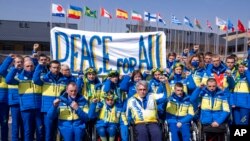 Valerii Sushkevych, president of the Ukraine National Paralympic Committee, and the Ukraine delegation raise their fists at the Paralympic Village during the Beijing Winter Paralympic Games in Zhangjiakou, China, March 10, 2022.