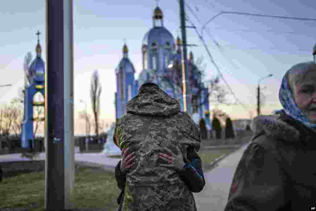 Un soldado abraza a un familiar que huye de la guerra, minutos antes de partir en autobús a Polonia, en Vinnytsia, Ucrania.