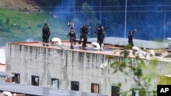 Policías toman posiciones en el techo de la prisión de Turi después de un motín el domingo 3 de abril de 2022, en Cuenca, Ecuador