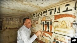 Mostafa Waziri, secretary general of the Supreme Council of Antiquities, views hieroglyphics inside a recently discovered tomb near the famed Step Pyramid, in Saqqara, south of Cairo, Egypt, March 19, 2022.