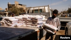 A worker holds a bag of flour in Jamila market, the wholesale market for food commodities, after a noticeable rise in the prices of flour and cooking oil, in Baghdad, Iraq, March 16, 2022.