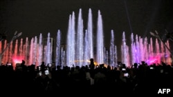 Orang-orang menonton pertunjukan air saat menghadiri upacara perayaan Noruz (Nowruz), Tahun Baru Persia, di pusat perbelanjaan Iran Mall di ibu kota Iran, Teheran, pada 20 Maret 2022. (Foto: AFP)