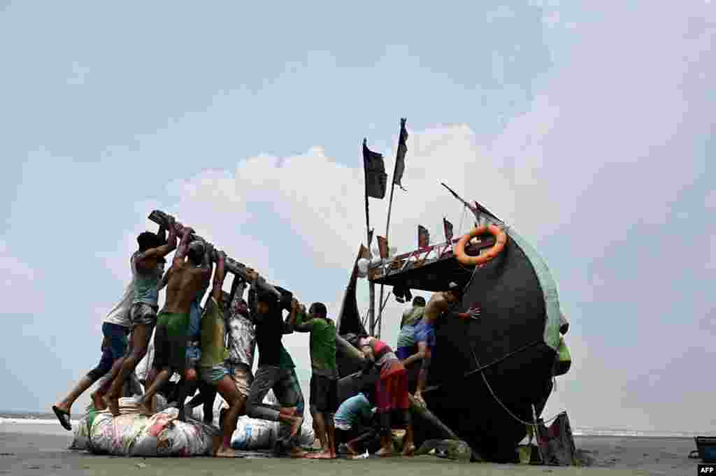 Fishermen lift a stranded boat after fishing from the Bay of Bengal in Teknaf, Bangladesh.