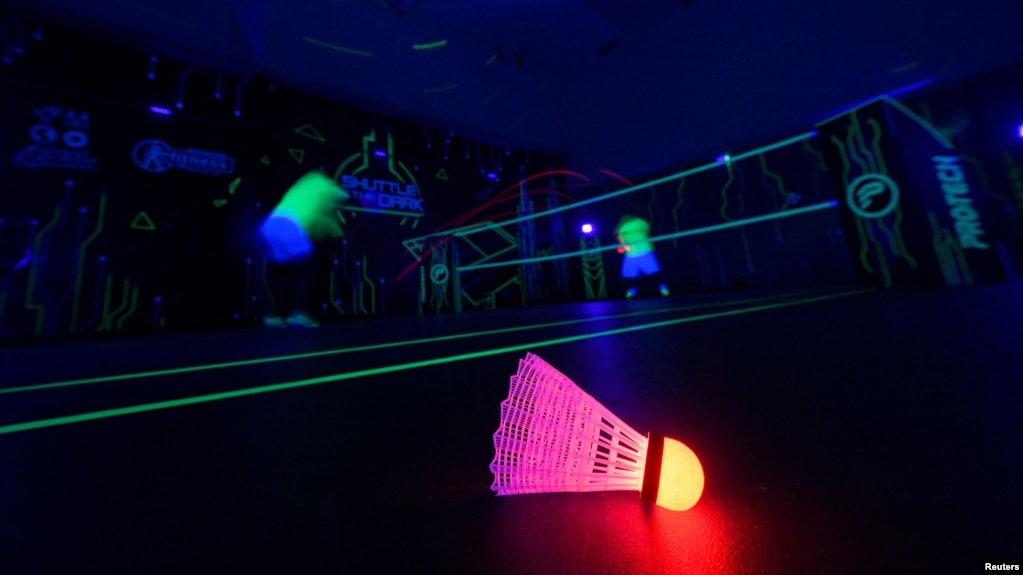 A badminton shuttlecock lit up in neon color at Shuttle in-the-dark badminton court in Kuala Lumpur, Malaysia, March 24, 2022. (REUTERS/Hasnoor Hussain)