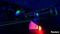 A badminton shuttlecock lit up in neon color at Shuttle in-the-dark badminton court in Kuala Lumpur, Malaysia, March 24, 2022. (REUTERS/Hasnoor Hussain)