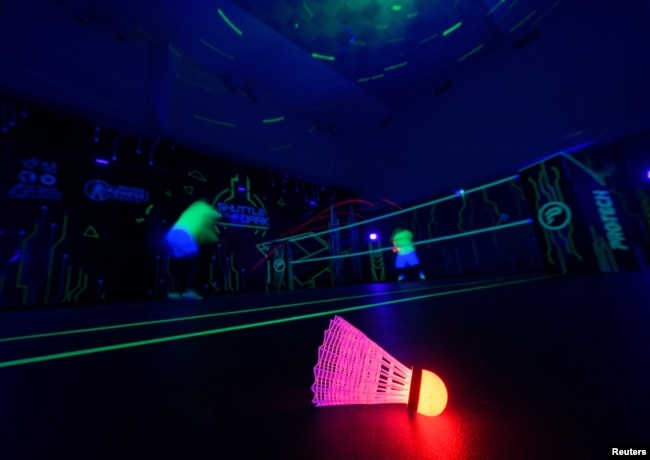 FILE - A badminton shuttlecock lit up in neon color at Shuttle in-the-dark badminton court in Kuala Lumpur, Malaysia, March 24, 2022. (REUTERS/Hasnoor Hussain)