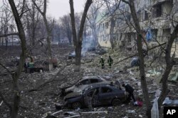 Ukrainian emergency employees work at the site of a maternity hospital obliterated by shelling, in Mariupol, Ukraine, March 9, 2022.