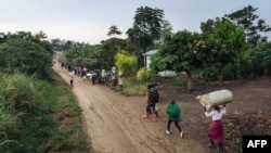 Des personnes déplacées fuient le lieu d'une attaque qui aurait été perpétrée par les ADF près de Beni, dans le Nord-Kivu, en RDC, le 18 février 2020.