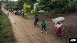 Displaced people carrying their belongings flee the scene of an attack allegedly perpetrated by the rebel group Allied Democratic Forces (ADF) in the Halungupa village near Beni. Taken 2.18.2020