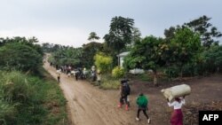Des personnes déplacées fuient le lieu d'une attaque qui aurait été perpétrée par le groupe rebelle des ADF dans le village de Halungupa près de Beni, Nord-Kivu, en RDC, le 18 février 2020. 