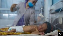 FILE - A nurse takes care of a baby in the neonatal intensive care unit of Malalai Maternity Hospital in Kabul, Afghanistan, Dec. 9, 2021.