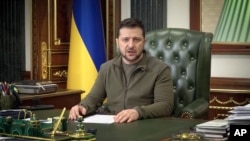 En esta imagen de un video proporcionado por la Oficina de Prensa Presidencial de Ucrania y publicado en Facebook, el presidente de Ucrania, Volodymyr Zelenskyy, habla en Kiev, Ucrania, la madrugada del 16 de marzo de 2022.