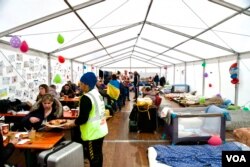 Una organización benéfica alimenta a mujeres y niños en una tienda reservada para ellos. [Jamie Dettmer/VOA]