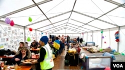 A Sikh charity feeds women and children in a tent set aside for them. (Jamie Dettmer/VOA)