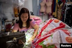 Leonora Buenviaje menjahit gaun dari karung beras bekas, di tokonya di Cainta, Provinsi Rizal, Filipina, 3 Maret 2022. (REUTERS/Lisa Marie David)
