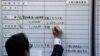 FILE - Workers of the Japan Council of Metalworkers' Union check the results of wage negotiations, at its headquarters in Tokyo, March 16, 2016. 