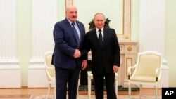 Russian President Vladimir Putin, right, and Belarusian President Alexander Lukashenko pose for a photo during their meeting in Moscow, March 11, 2022.