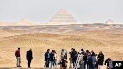 Reporters prepare to enter a recently discovered tomb near the famed Step Pyramid, in Saqqara, south of Cairo, Egypt, March 19, 2022. The five tombs date back to the Old Kingdom and the First Intermediate Period.