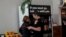 Amy and Chris Hillyard, owners of Farley's East cafe that closed due to the financial crisis caused by COVID-19, embrace at the cafe in Oakland, Calif., March 18, 2020.