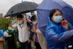 Kerabat penumpang pesawat China Eastern Flight 5735 tiba di dekat lokasi kecelakaan, Rabu, 23 Maret 2022, desa Lu, di provinsi Guangxi, China barat daya. (AP/Ng Han Guan)