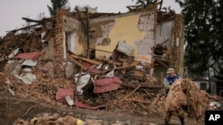 A man removes debris from buildings destroyed during fighting between Russian and Ukrainian forces, outside Kyiv, Ukraine, April 1, 2022. Emergency relief and evacuation convoys for the besieged Ukrainian city of Mariupol remained in doubt Friday followin