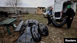 Voluntarios descargan de una furgoneta bolsas con cuerpos de civiles que, según los residentes, fueron asesinados por soldados del ejército ruso, en medio de la invasión rusa de Ucrania, en Bucha, en la región de Kiev, Ucrania, el 4 de abril de 2022.
